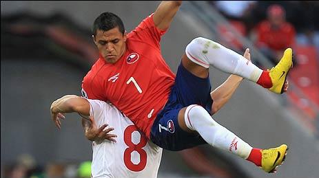 Sanchez of Chile tangles with Inler of Switzerland